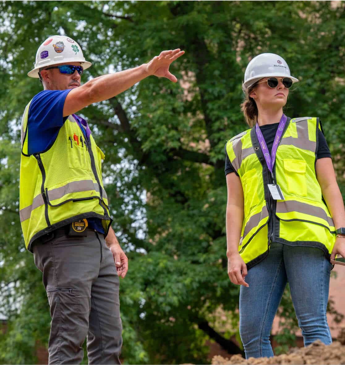 Image of male and female McGough project leaders in safety gear talking at a work site