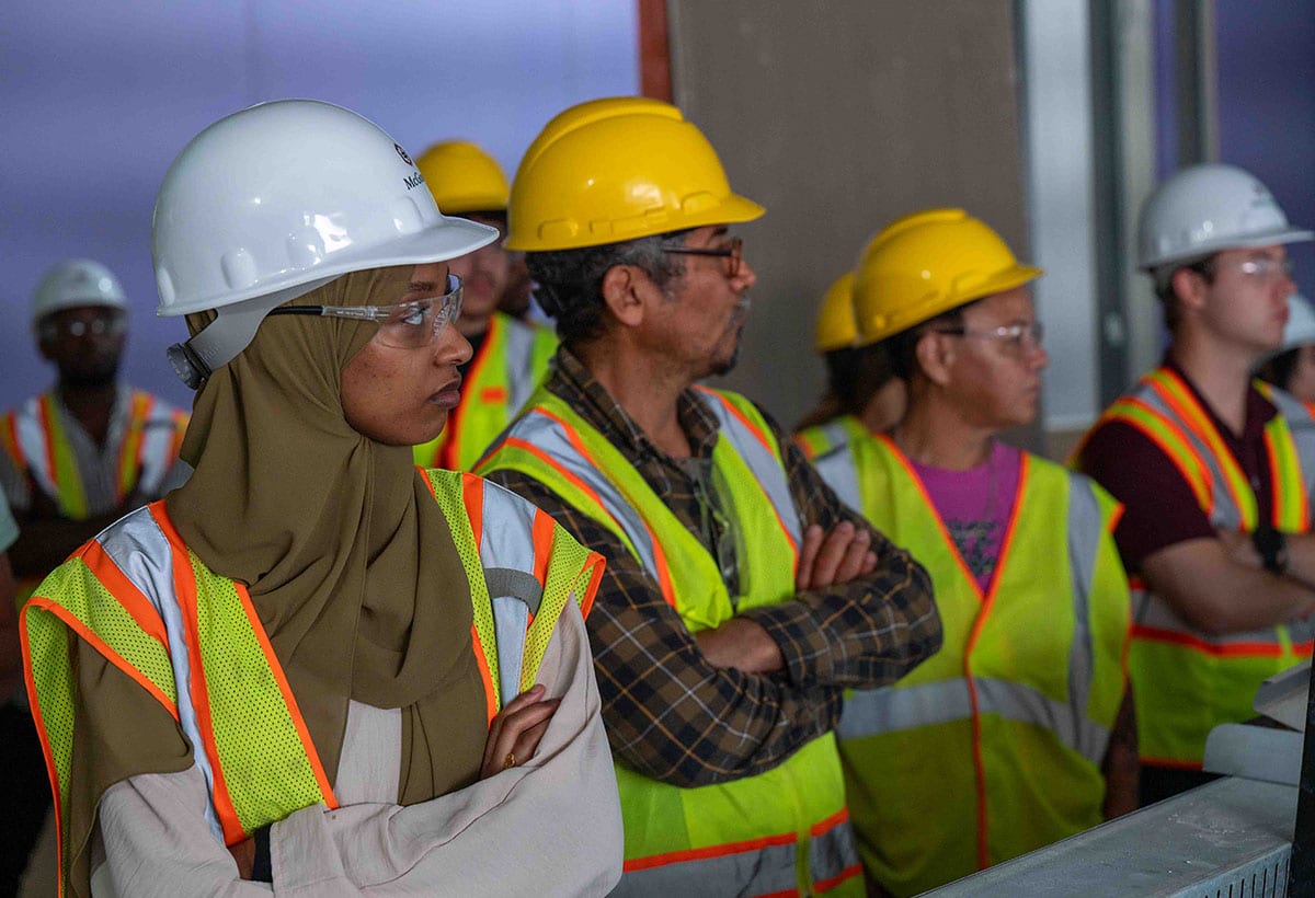 A diverse group of McGough construction workers, of different ages, genders and ethnicities, on a job site