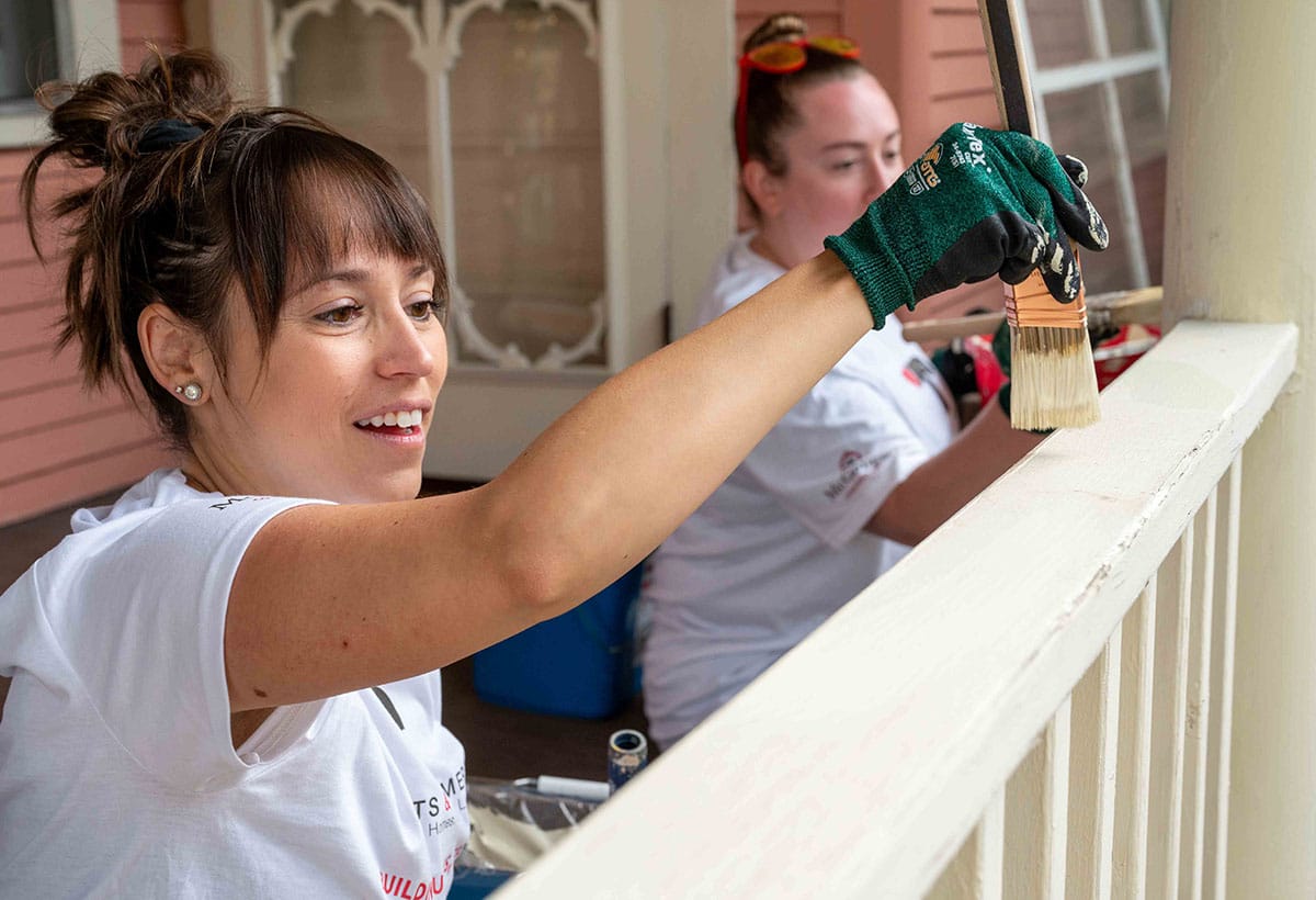 Two women painting at a volunteer housing project