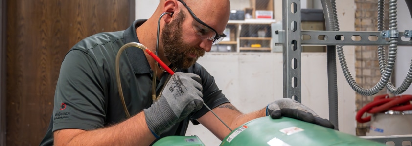 A McGough facility management specialist repairing building equipment