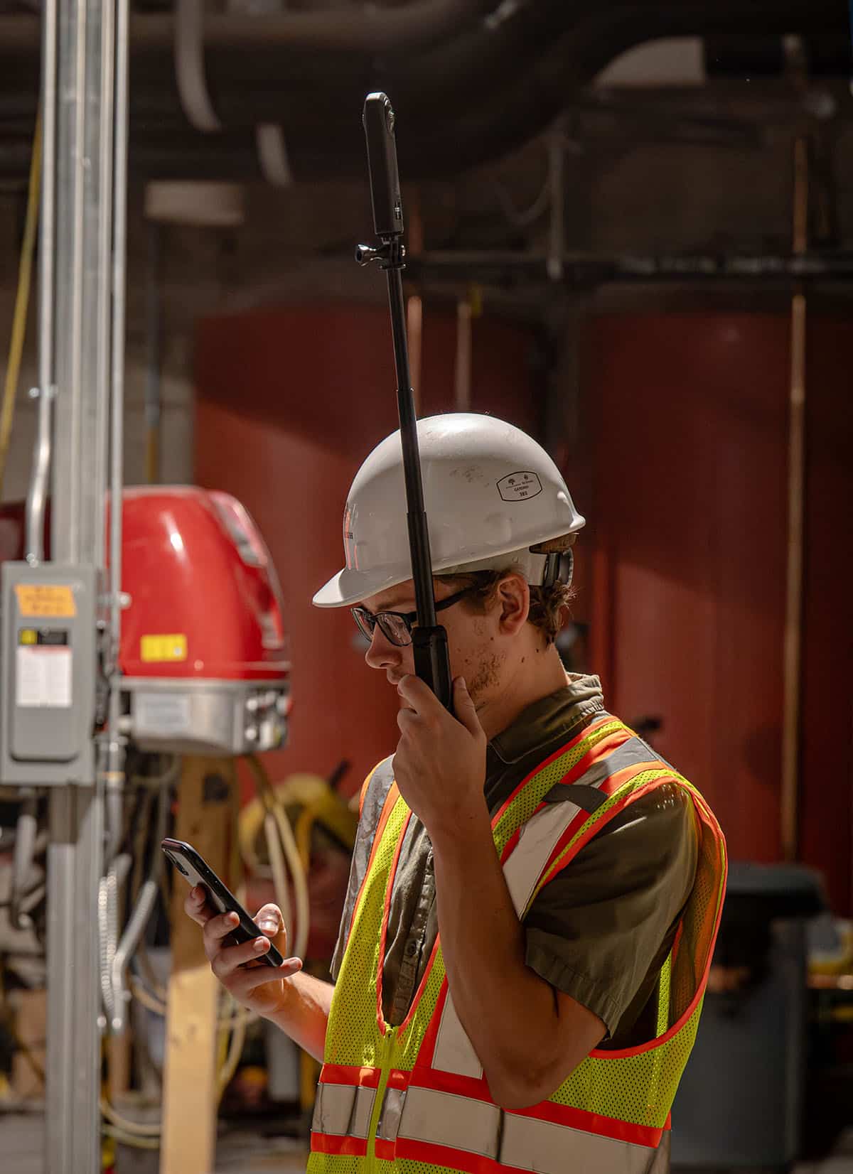 McGough engineer on a job site using handheld electronic measurement devices