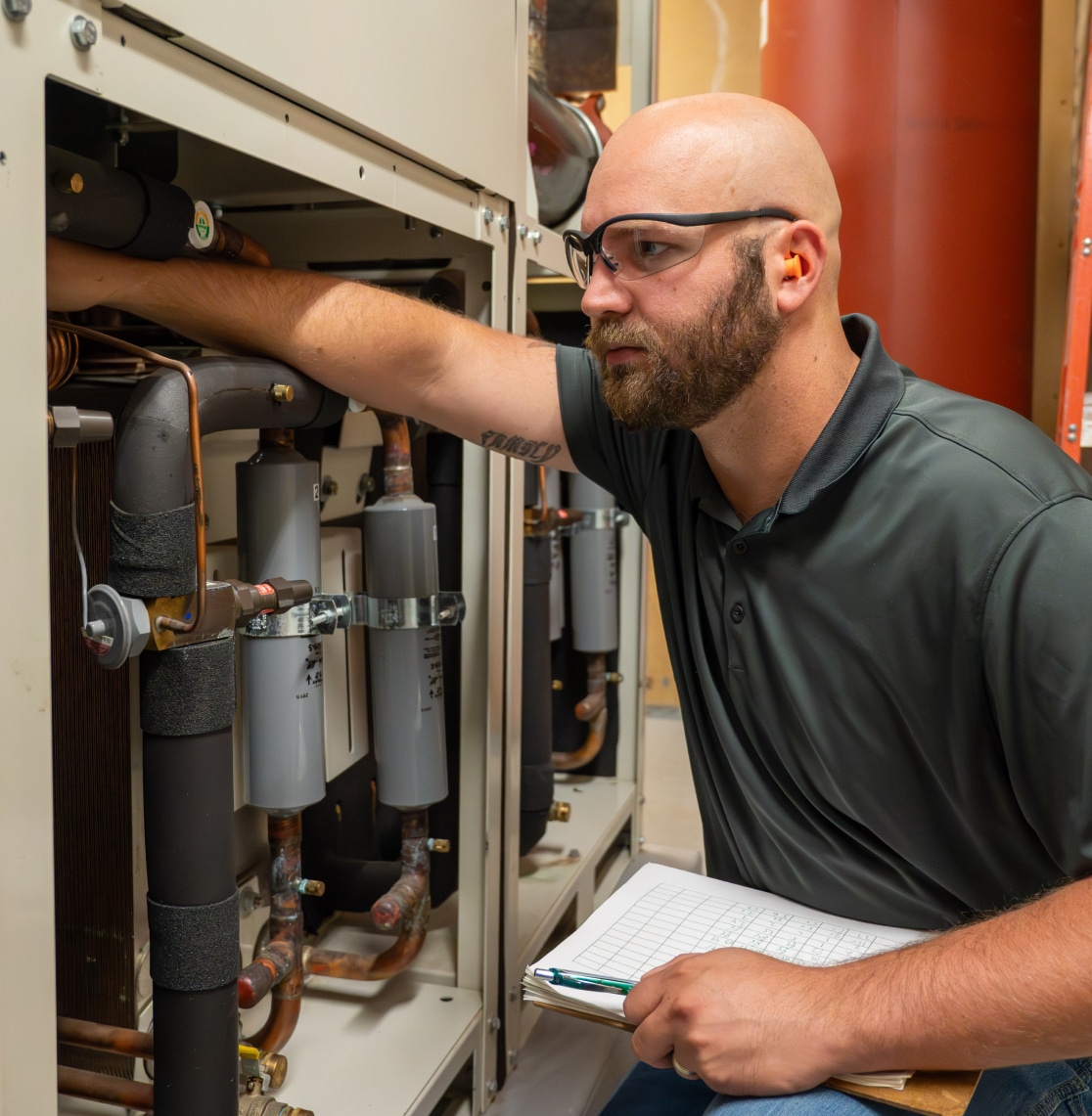 A McGough facility management professional working on building equipment