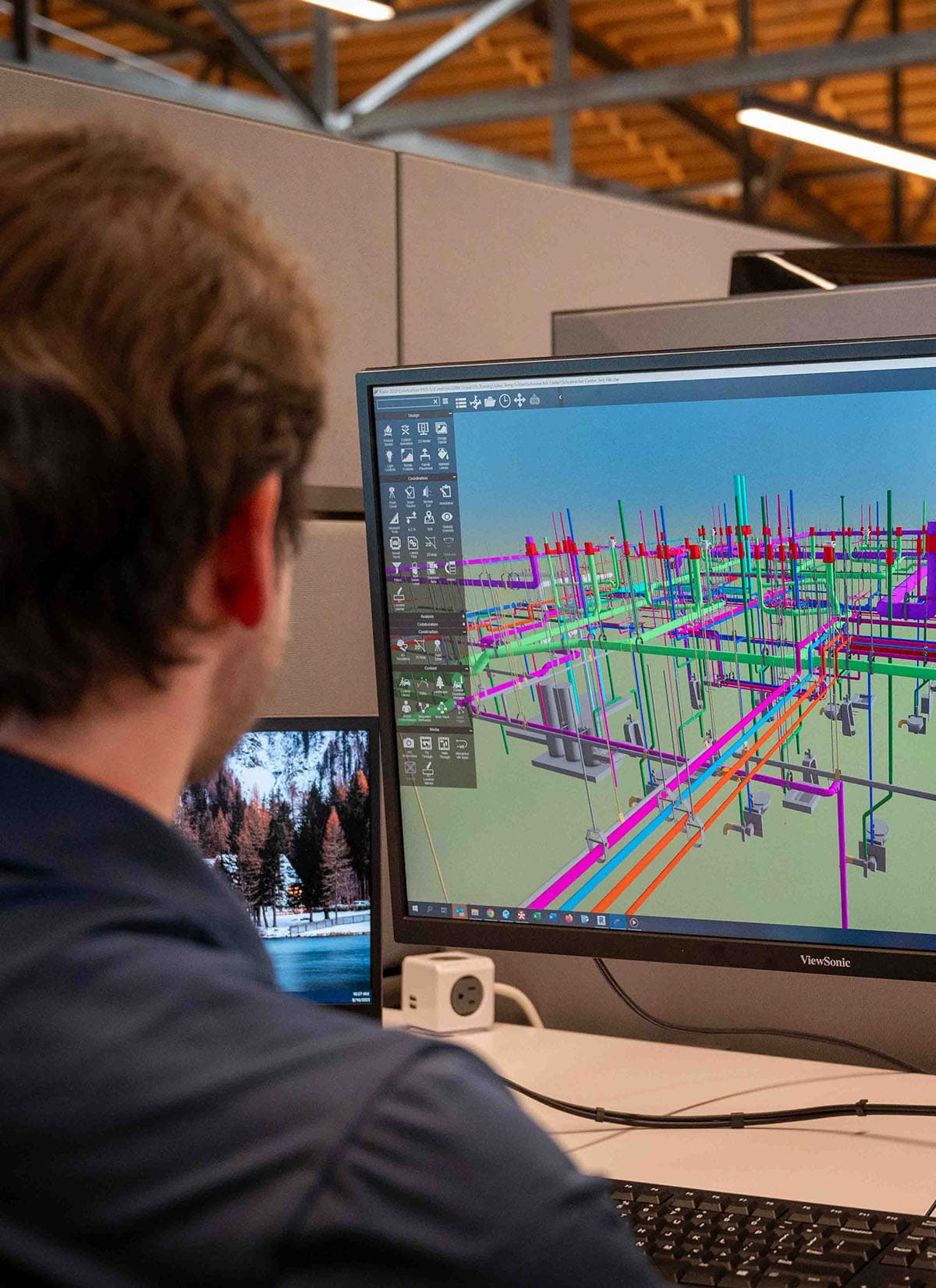 Image of a McGough engineer at a computer working on a 3D rendering of a project