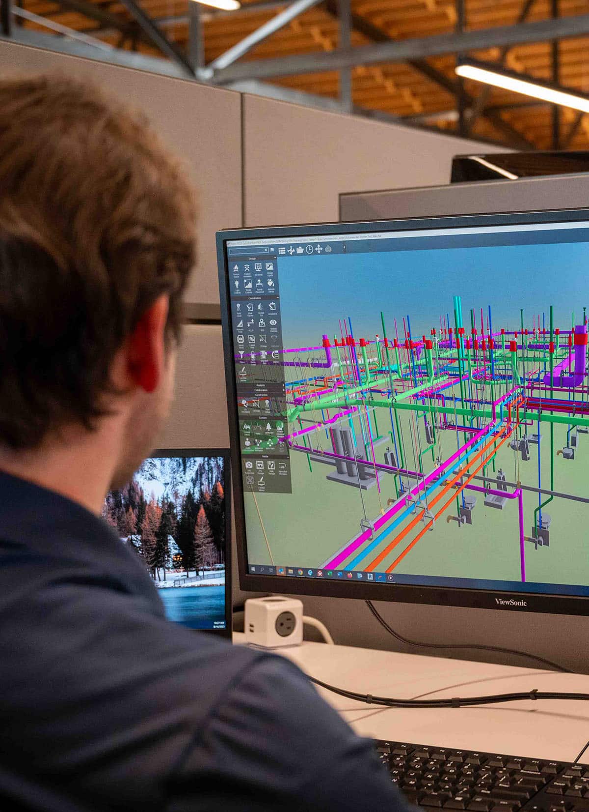 An engineer at a computer working on a 3D rendering of a project