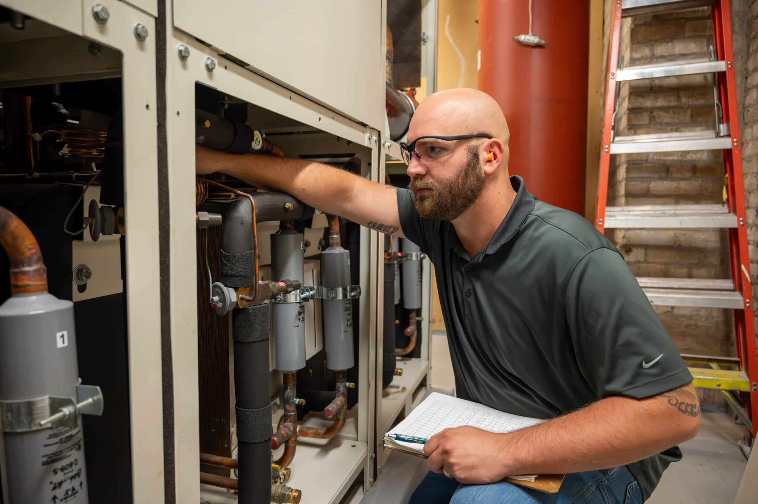 Image of Josh Yates, Chief Building Engineer for McGough, working on equipment