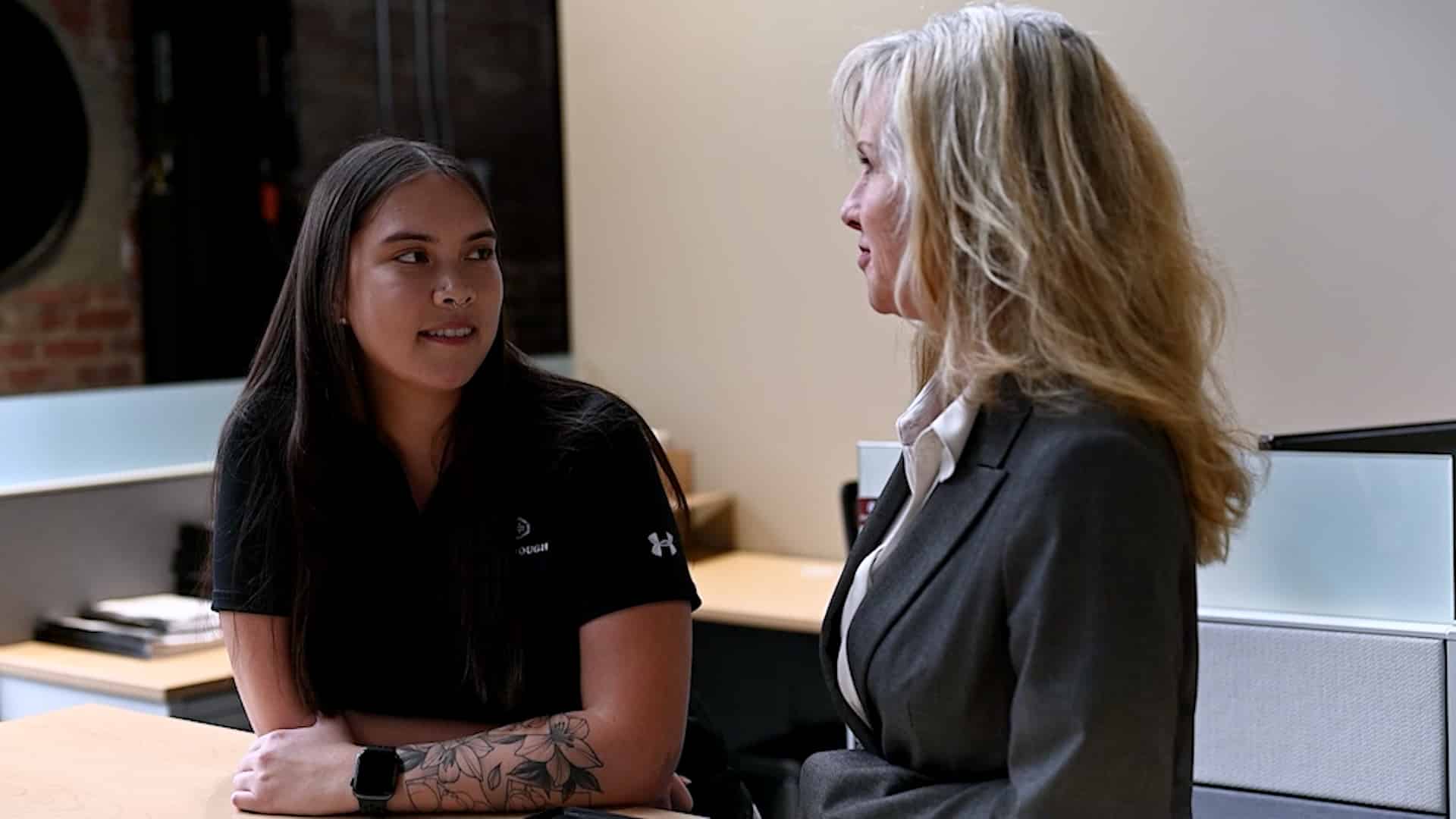 A former McGough intern (now an employee) talking with her mentor in an office