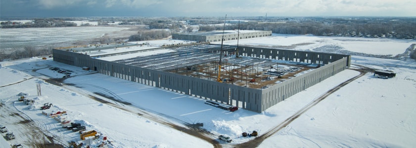 Arial image of a large warehouse/factory building under construction in winter