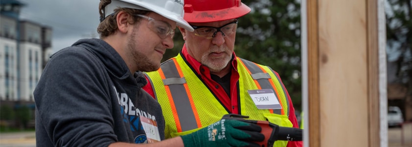 Two McGough workers examining a part of a building