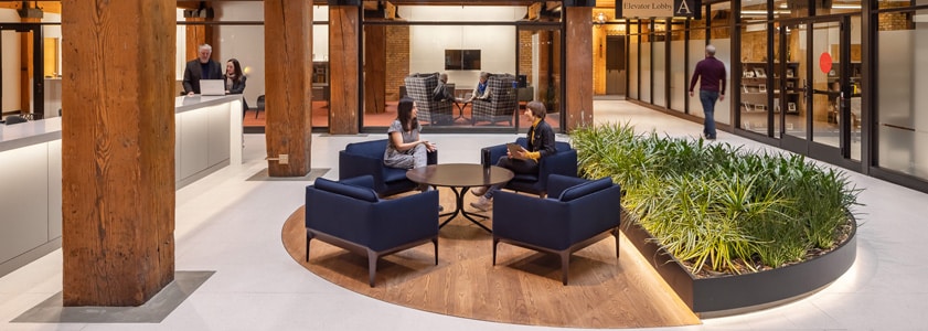 A McGough facility management expert and client meeting in an office lobby.